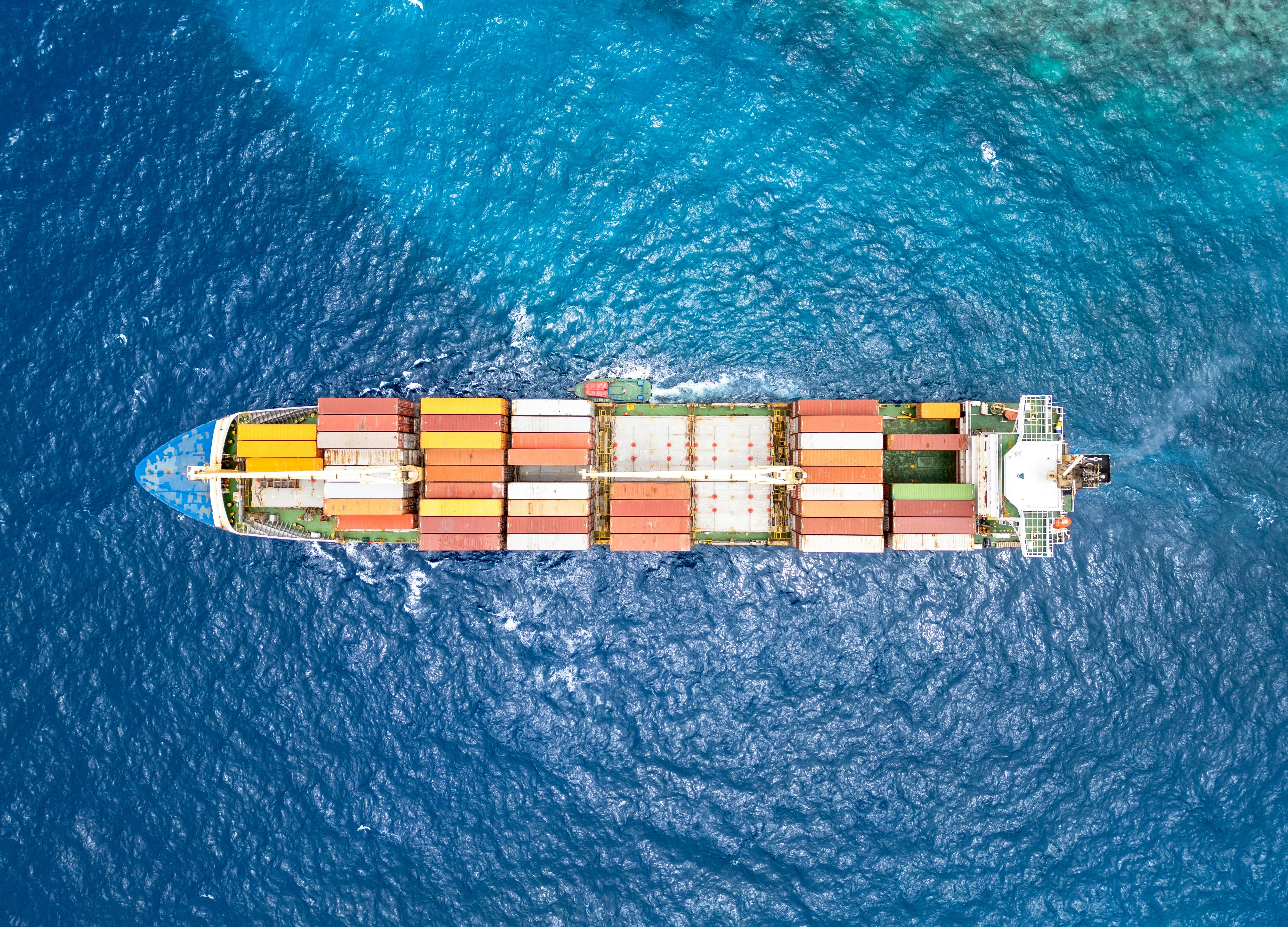 Aerial view of cargo ship with containers at sea